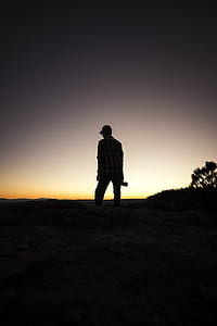 silhouette man standing on mountain under sunset thumbnail
