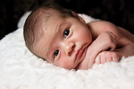 close-up photography of baby on white textile thumbnail
