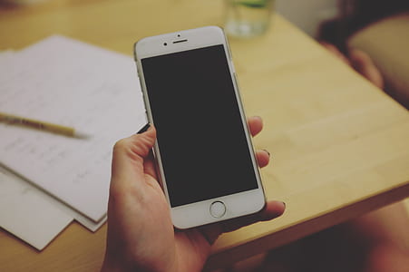 selective focus photography of person holding turned off iPhone 6 thumbnail