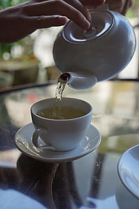 person pouring beverage from teapot to mug thumbnail