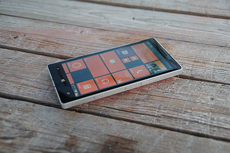 turned-on Windows smartphone on brown wooden surface thumbnail