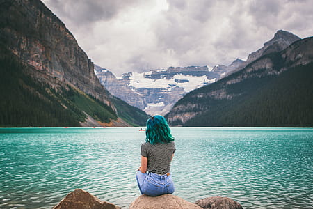 woman sitting on stone facing sea thumbnail