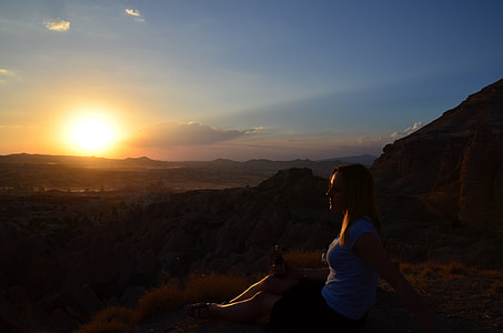 woman sitting on cliff at sunrise thumbnail