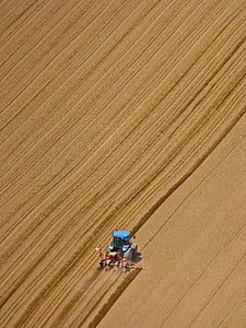 bird's-eye view photography of farm tractor on brown field thumbnail