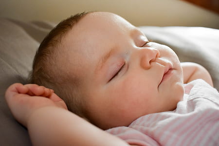 baby sleeping on top of brown surface thumbnail