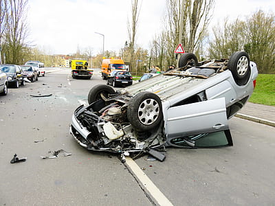 gray sedan turned over at the center of the road thumbnail