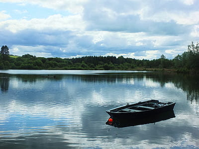 jon boat on lake under white clouds thumbnail