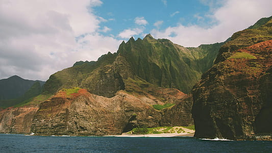 mountain near body of water during cloudy day thumbnail