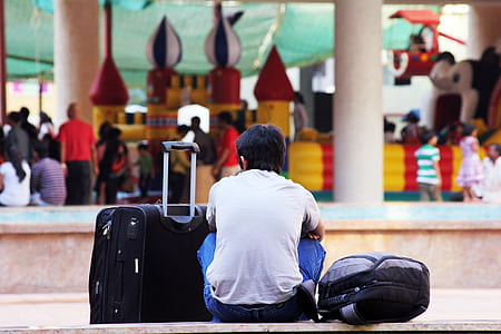 selective focus photography of man sitting in front of people during daytime thumbnail
