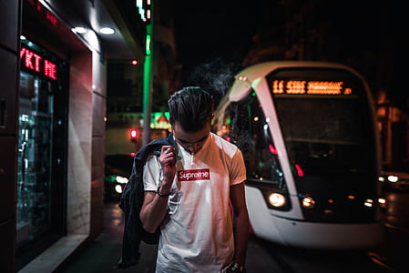 man holding his jacket while looking at the ground thumbnail