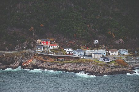 houses near cliff and body of water thumbnail