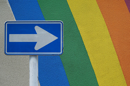 white and blue arrow signage near painted wall thumbnail