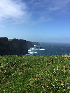 body of water beside rock formation at day thumbnail