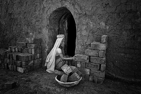 woman sitting on ground holding brick thumbnail