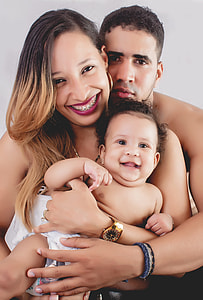 man and woman hugging baby smiling thumbnail