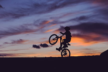 silhouette of person riding bicycle during golden hour thumbnail