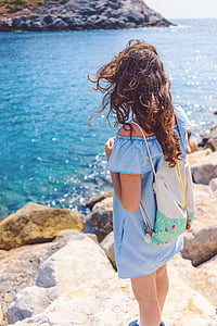photography of woman standing on stone while looking at water thumbnail