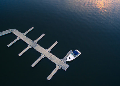 boat beside gray dock during daytime thumbnail