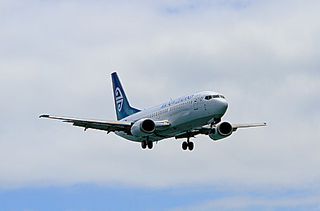 airplane under cloudy blue sky thumbnail