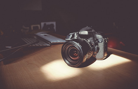 black Canon DSLR camera on table thumbnail