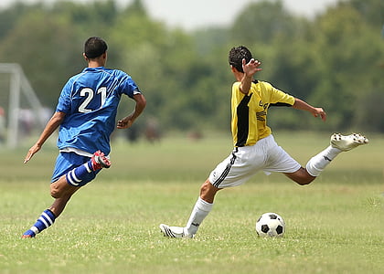 two man playing soccer during daytime thumbnail