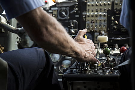 person sitting on cockpit holding black and white lever thumbnail