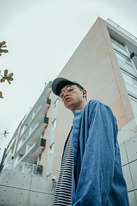low angle photography of man standing against wall thumbnail