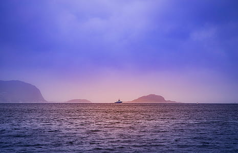 boat on body of water near mountain cliffs thumbnail