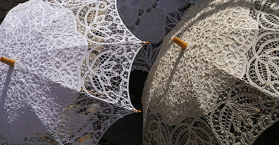 photo of two beige and white lace umbrellas thumbnail