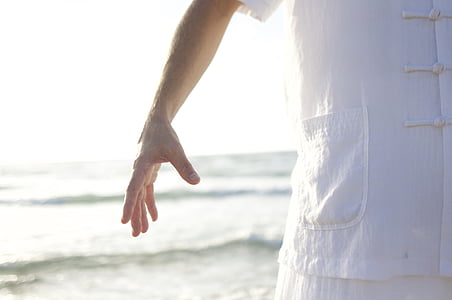 person wearing white shirt standing near seashore thumbnail