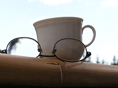 eyeglasses beside white mug thumbnail