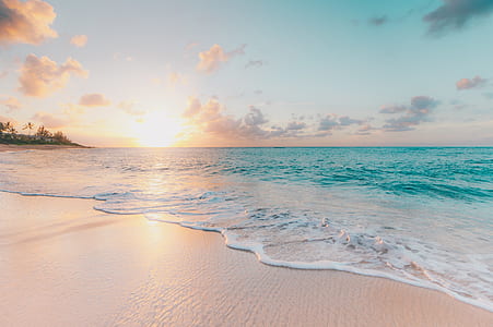 white sand beach with calm water at sunset thumbnail