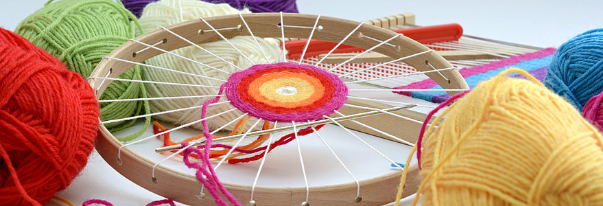 round brown wooden frame with assorted-color threads and yarns thumbnail