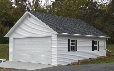 white garage with black roof tiles near forest at daytime thumbnail