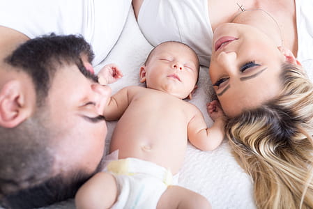 man and woman beside baby thumbnail