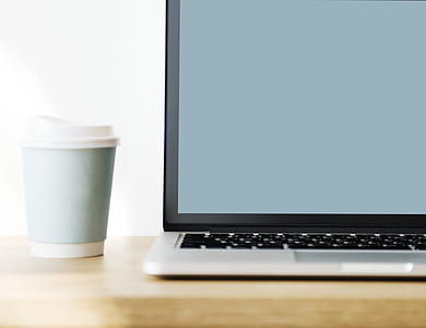 gray laptop computer beside gray and white plastic cup thumbnail