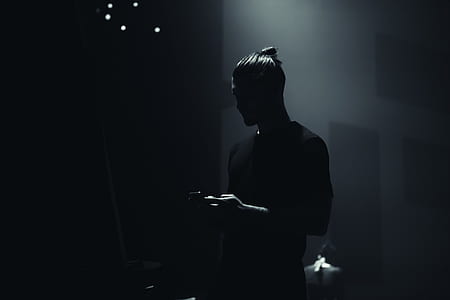 silhouette photo of man standing at stage thumbnail