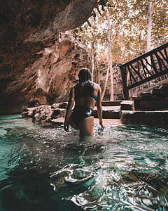 woman walking on body of water during daytime thumbnail