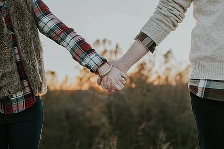 man and woman holding hands during daytime thumbnail