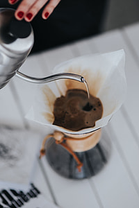 Woman pouring water in Chemex filter coffee maker thumbnail