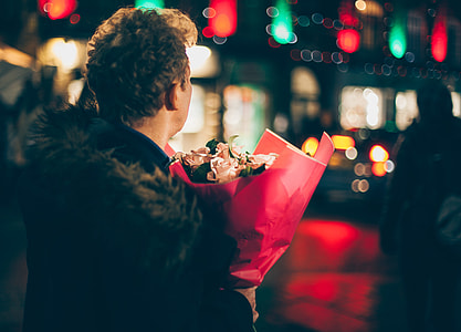 person holding flower bouquet at night thumbnail