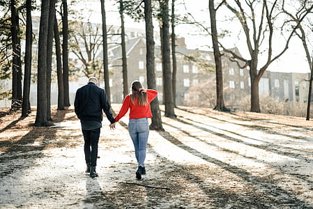 man and woman walking on the trees thumbnail