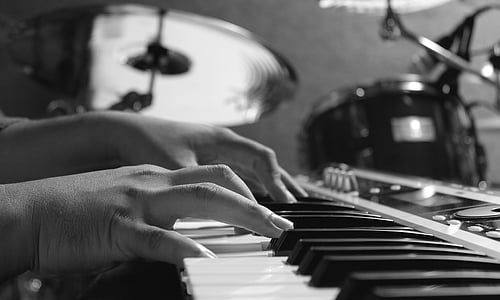 grayscale photo of person hand playing piano thumbnail
