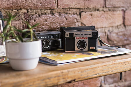 photography of three black SLR camera on brown wooden shelf thumbnail