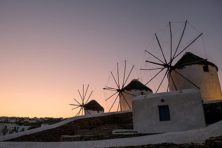 three brown windmills under gray sky during sunset thumbnail