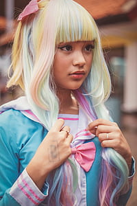 woman wearing blue cosplay costume holding her wig during daytime thumbnail