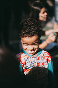 Selective Focus Photography of a Boy Who Were Smiling in With Red and Blue Hooded Jacket thumbnail