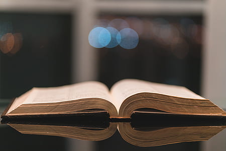 selective focus photography of opened book on black table thumbnail