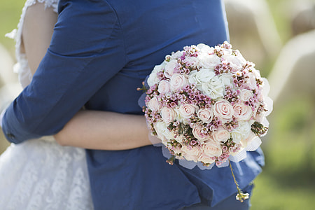 woman hugging man while holding pink and white rose bouquet thumbnail