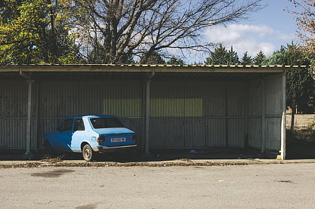 blue sedan parked under the garage thumbnail
